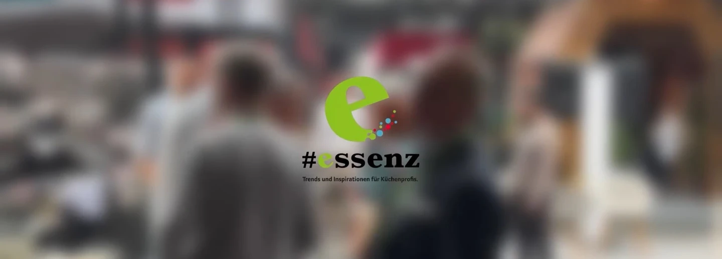 Im Hintergrud Messebesucher, im Vordergrund das essenz Logo.