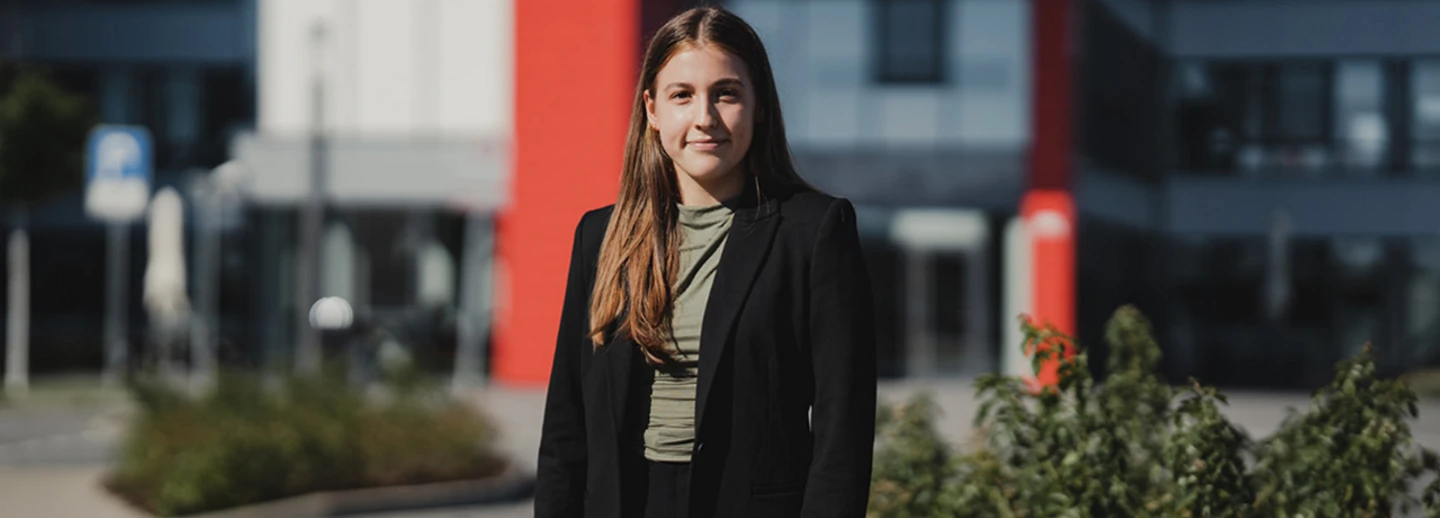 Portätfoto einer dualen Studentin von Transgourmet Deutschland vor dem Eingang des Zentralgebäudes in Riedstadt