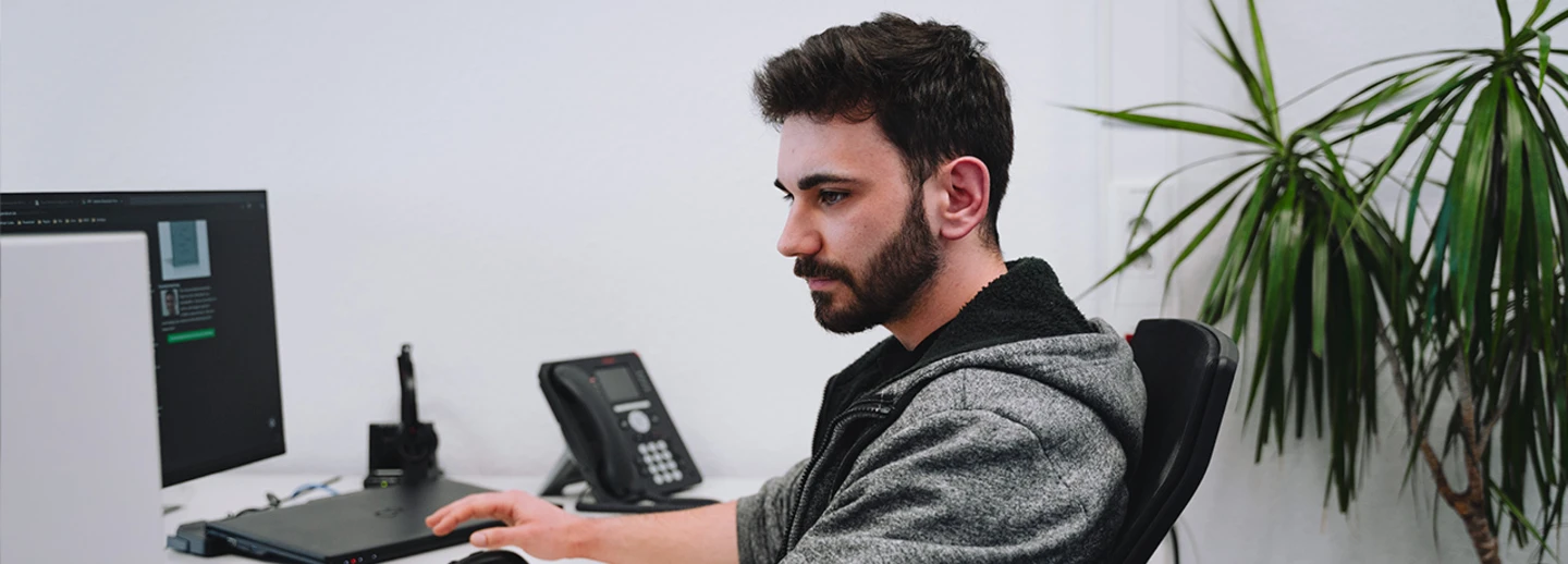 Ein Auszubildender zum Fachinformatiker für Systemintegration an seinem Büroarbeitsplatz