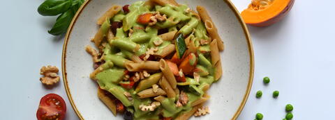 Vollkorn Penne mit getrockneten Tomaten, Zucchini, Kürbiswürfeln und grüner Basilikumsauce, bestreut mit gehackten Walnüssen Vollkorn Penne mit getrockneten Tomaten, Zucchini, Kürbiswürfeln und grüner Basilikumsauce, bestreut mit gehackten Walnüssen