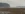Blick über das Feld und auf einen Silberreiher bei der Mäusejagd