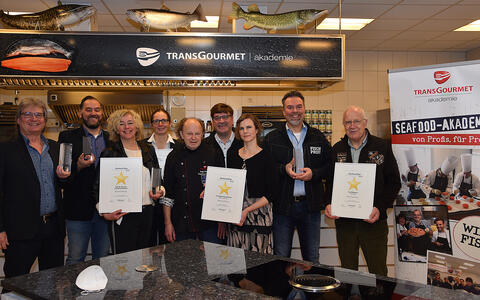 Mitarbeiter von Transgourmet Seafood präsentieren die Auszeichnung in der Seafood Akademie in Bremerhaven