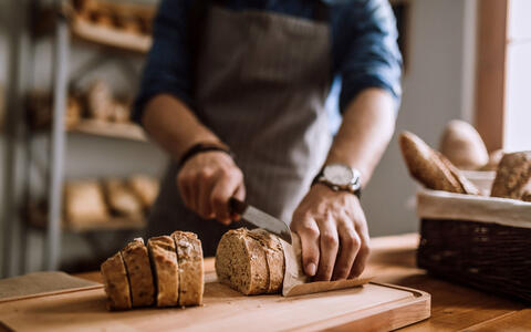 Person beim Brot schneiden