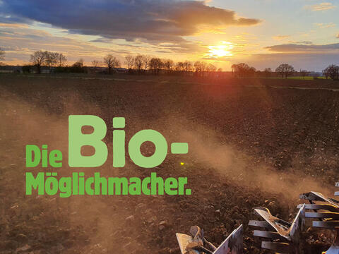 Stimmungsbild "Die Bio-Möglichmacher": Landmaschine pflügt ein Feld im Sonnenuntergang