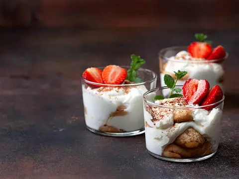 Erdbeertiramisu in drei kleinen Gläsern.