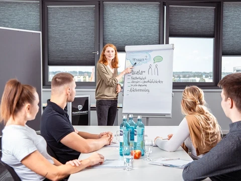 Seminarteilnehmer und Referentin im Konferenzraum